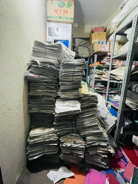 Stacks of bundled newsprint against a wall
